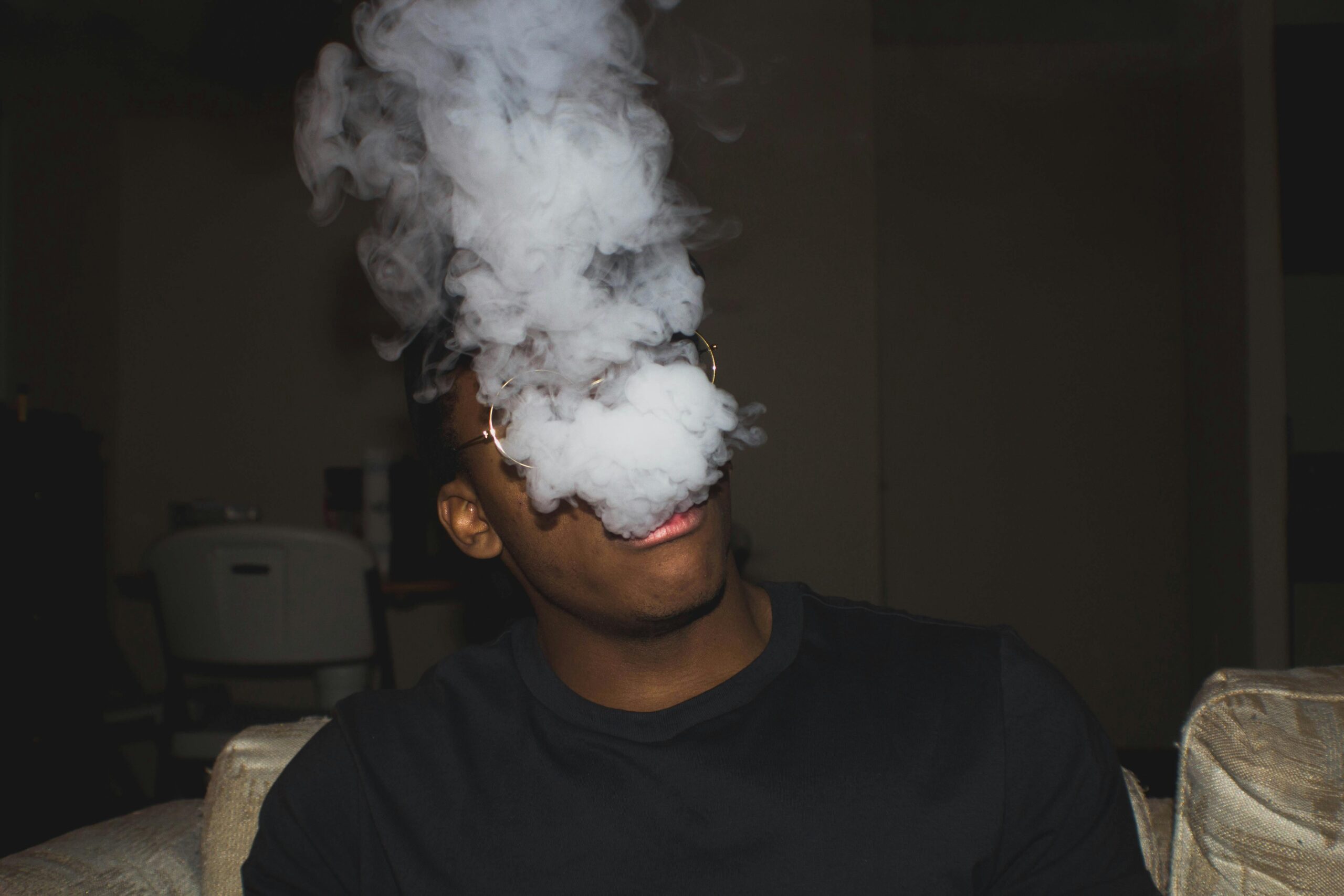 a guy vaping with smoke covering the face