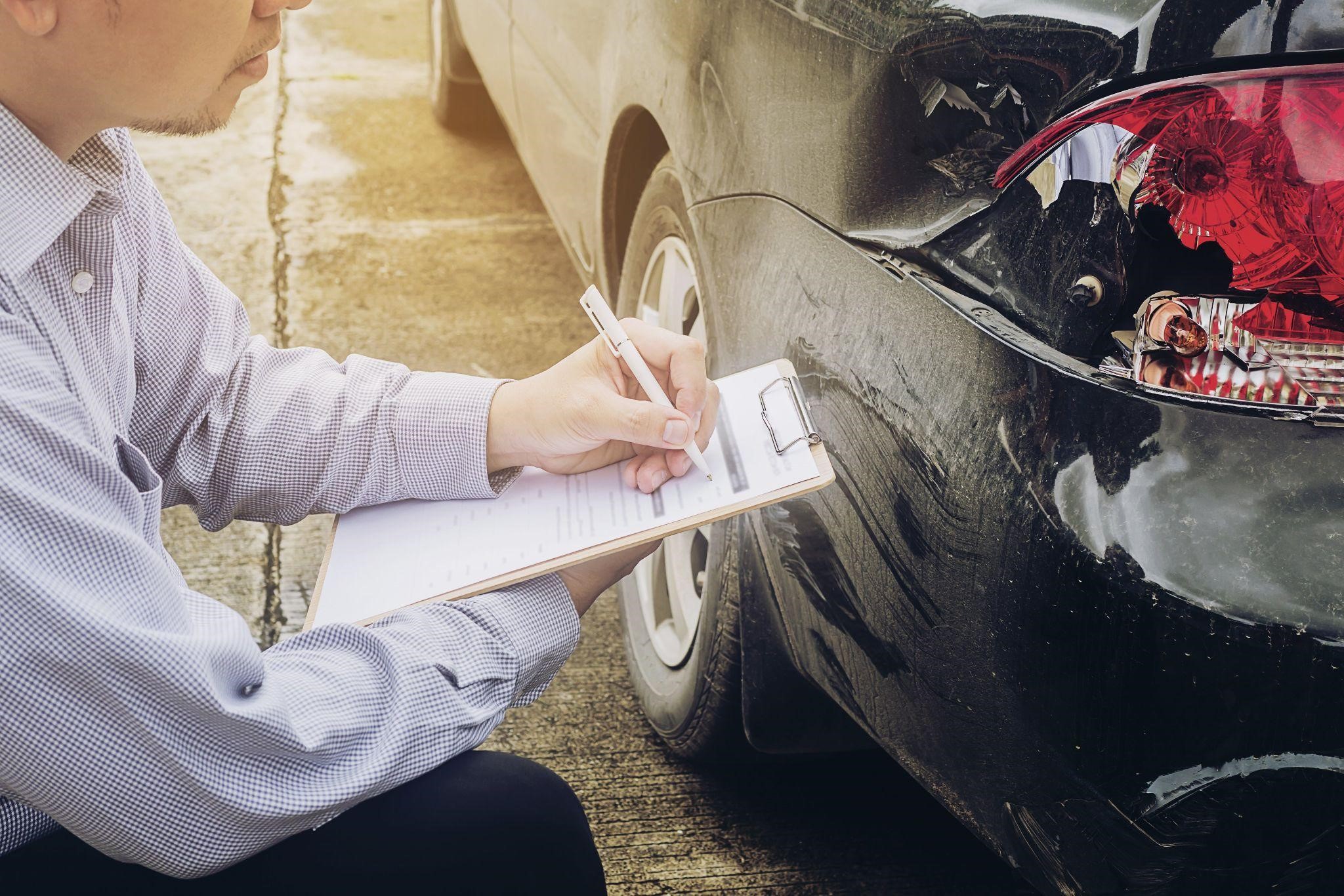 a man listing the damages of the car